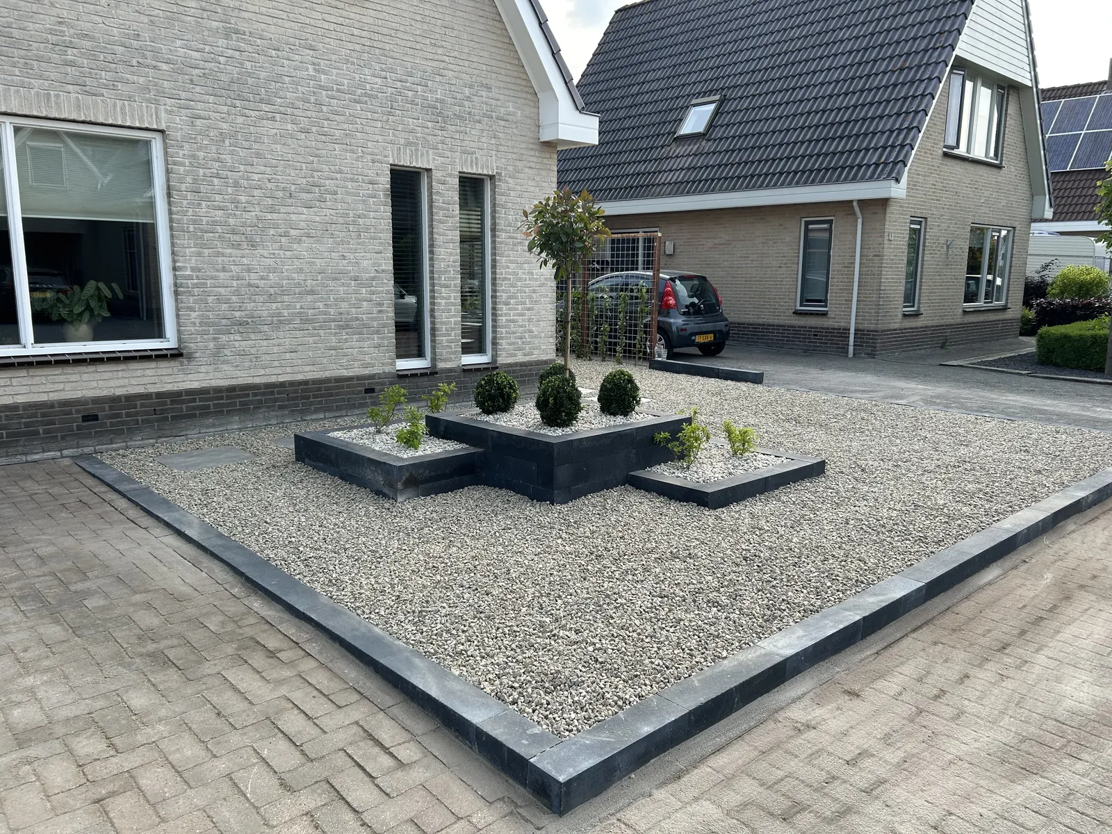 Voortuin met grind en hederaschutting